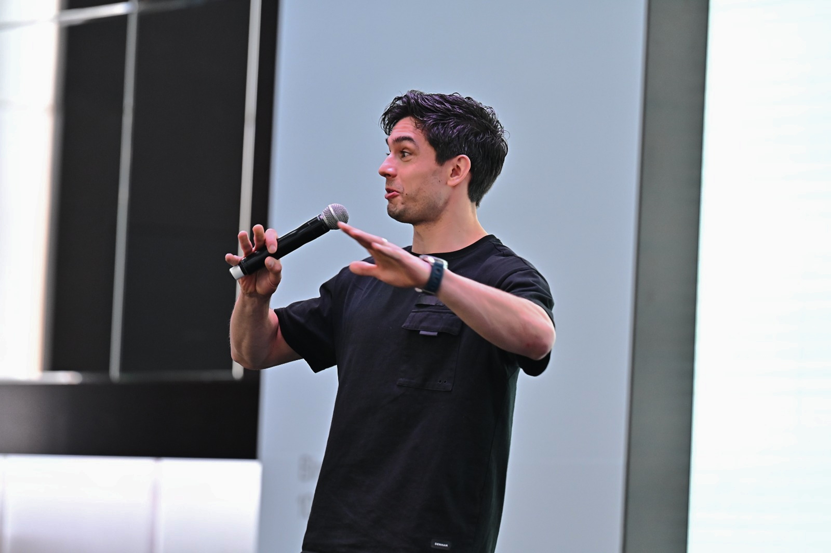 A person holds a microphone while speaking to an audience in Bird's keynote event in Dubai.