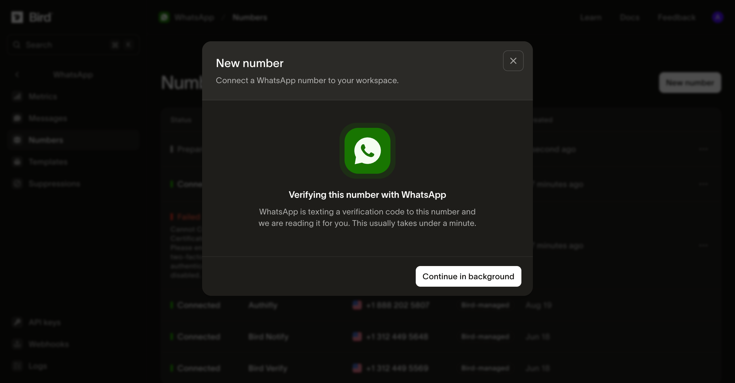 The New number dialog in the Bird dashboard mid-verification: a WhatsApp logo above the heading "Verifying this number with WhatsApp", with a Continue in background button, over the dimmed Numbers list where the new row already reads Preparing